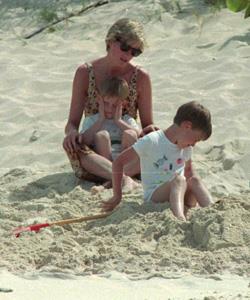 Summer fun with her sons, the Princess relaxes on the beach at Necker Island in the British Virgin Islands. Prince Harry, five, is in her lap as she speaks to Prince William, six, during their 1990 vacation.