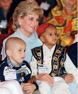 Diana, Princess of Wales holds two young patients on her knees during her visit to Imran Khan's cancer hospital in Lahore, Pakistan in April 1996.