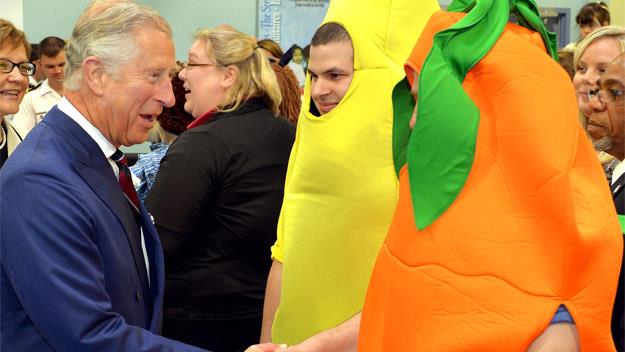 Prince Charles shaking hands with an orange