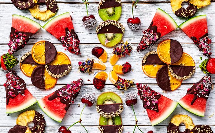 A variety of tropical fruits dipped in chocolate and toppings.