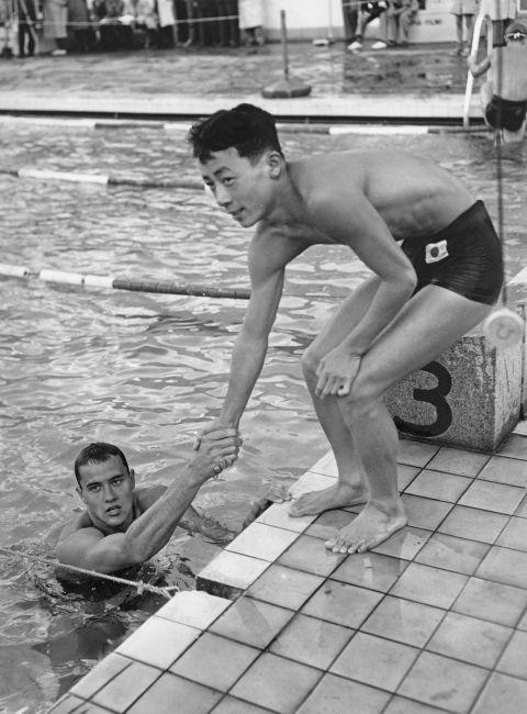 <p> <strong>1952</strong><p> <p> American swimmer Ronald Gora shaking hands with his Japanese opponent, Toru Gotu, in Helsinki following a race. In the '50s, we see the rise of functional synthetic fabrics like Spandex and Lycra that are stretchy and often used to make swimwear.