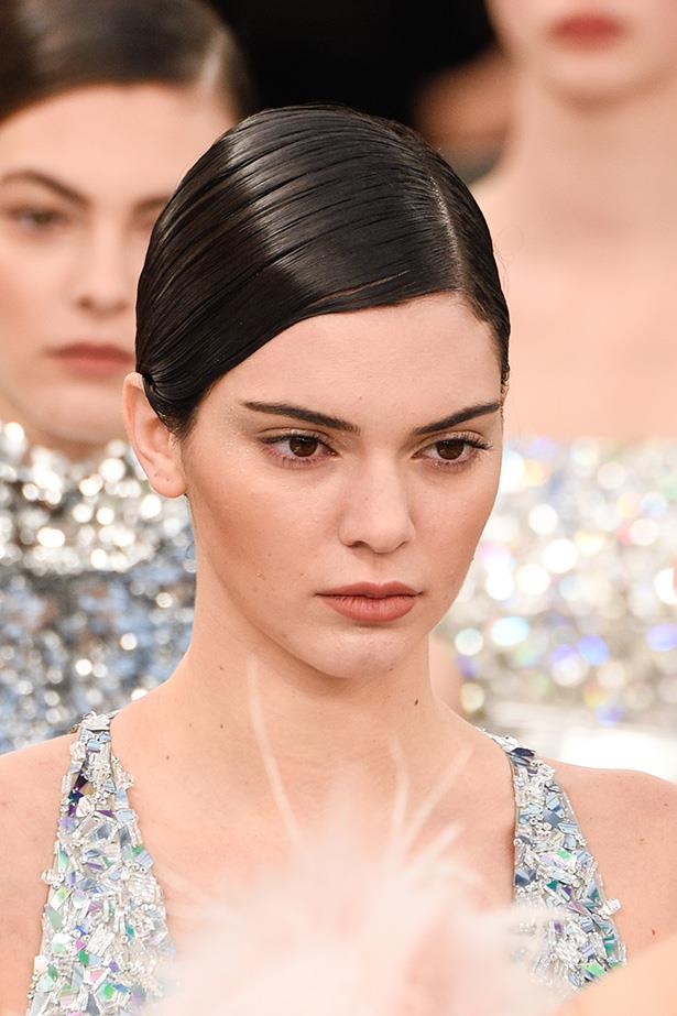 At the Chanel Haute Couture show in Paris last night, hair was slicked into a deep side part and a flattened chignon, created by Sam McKnight. A LOT of bobby pins are securing it's unique shape. <br> <br> <em>Getty</em>