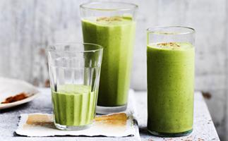 Three tall glasses holding a light-green smoothie, garnished with a sprinkle of cinnamon.