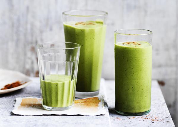 Three tall glasses holding a light-green smoothie, garnished with a sprinkle of cinnamon.
