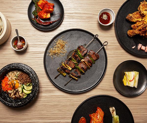 An assortment of dishes at Sydney's Sang by Mabasa, including bibimbap, skewers of scotch fillet and spring onion and fried chicken.