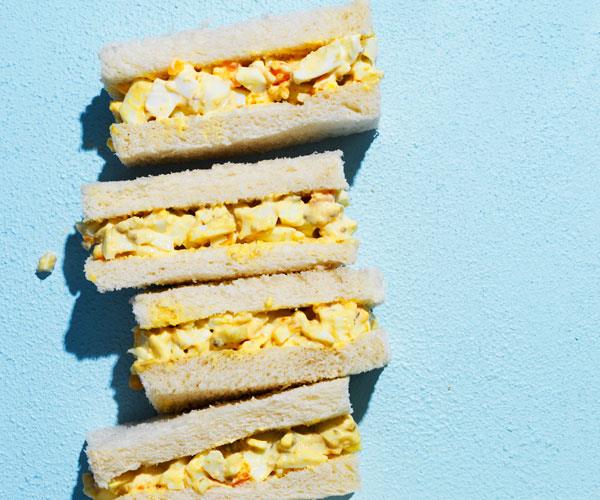 A stack of Japanese egg sandwiches on a blue background.