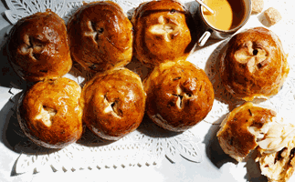 Eight savoury buns together with a saucer of syrup. 