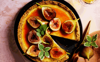 Cheesecake topped with halved figs and golden-orange syrup.