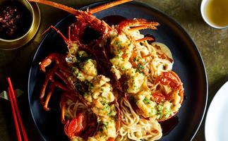 Bird's eye view of longevity noodles toped with two lobster halves