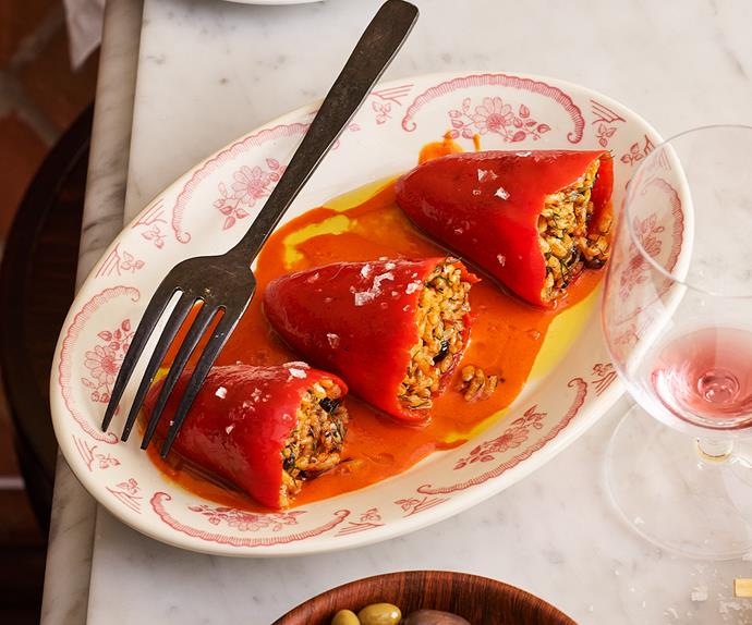 Three red peppers stuffed with rice on a dainty plate