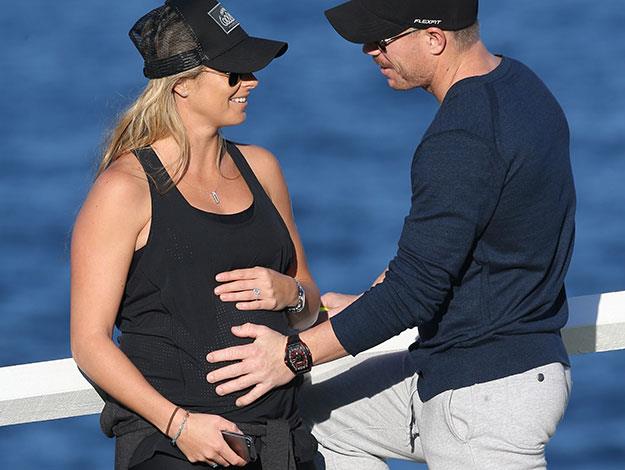 Cricketer David Warne looks proud as he feels fiancée Candice Falzon's baby bump.