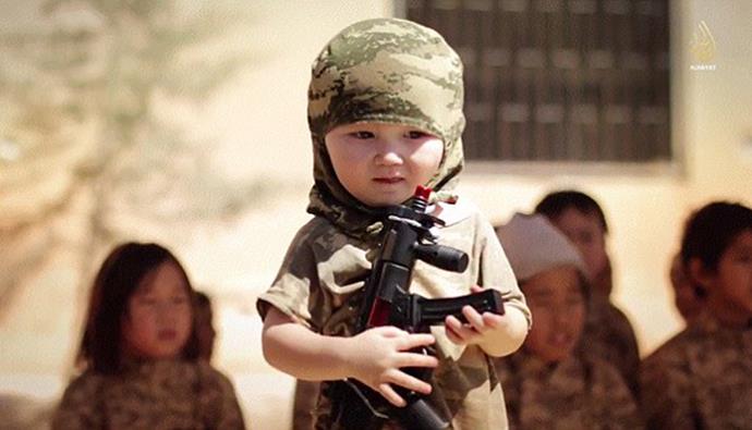 In another propaganda video Daesh shows a toddler brandishing a toy sub-machine gun while wearing military fatigues, reportedly taken at a child training camp in Kazakhstan.