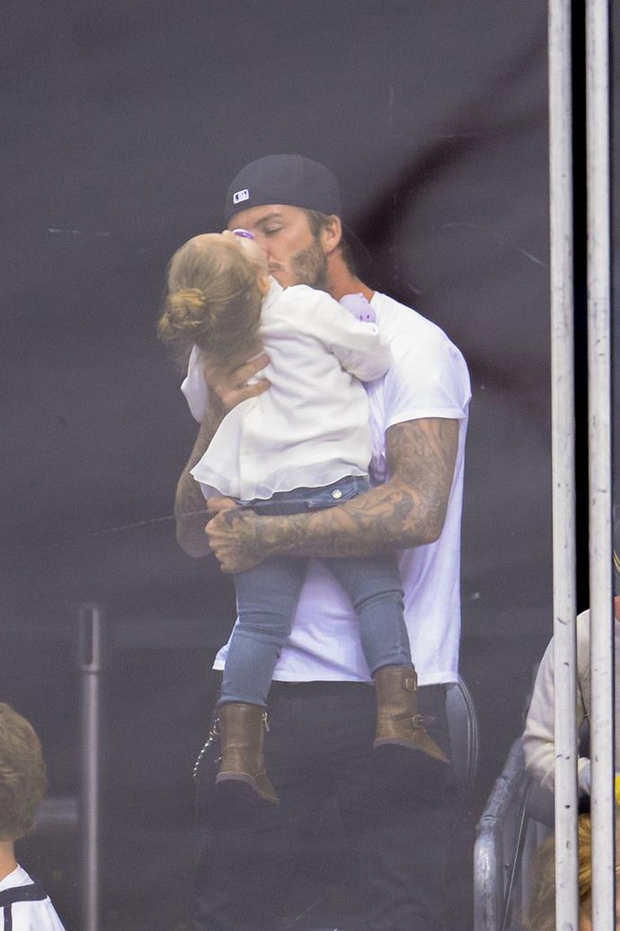 David plants a kiss on his daughter Harper at the Staples Center in LA.