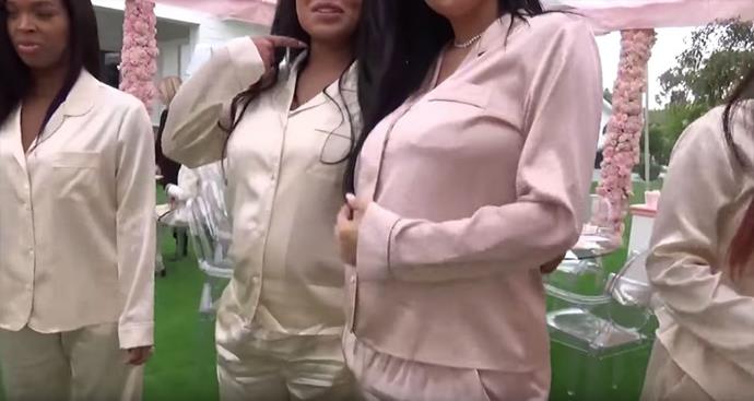 Kylie Jenner showcases her bump in her silky pink pyjamas at her baby shower.