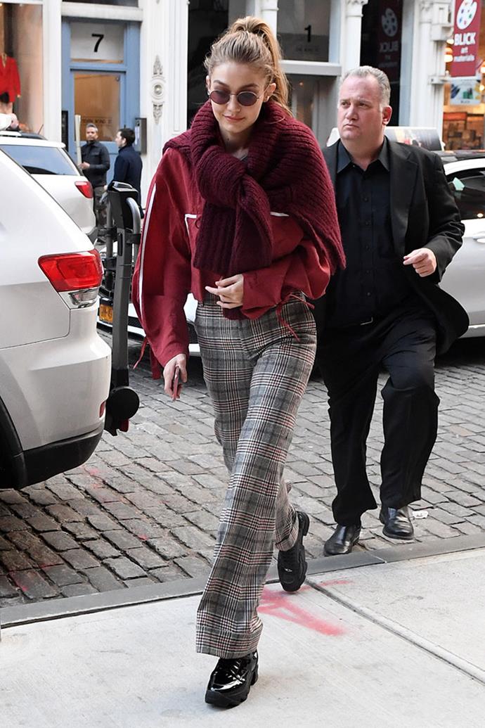 Gigi Hadid just stepped out in New York City for the first time since announcing her split with Zayn Malik and boy, she looks good. Here she's wearing plaid trousers, a burgundy jumper with another tied around her neck. The look was finished with matching shades and chunky black boots.