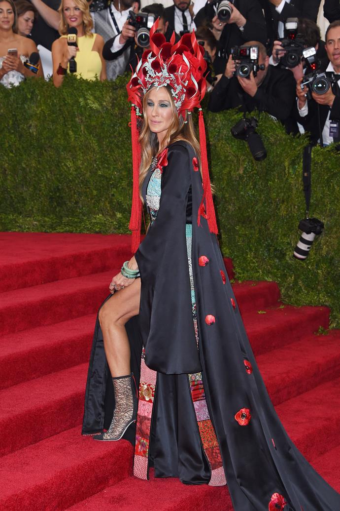 **2015: SARAH JESSICA PARKER in H&M and Philip Treacy**
<br><br>
While many are quick to hail Rihanna as the queen of the Met, Sarah Jessica Parker also has a history of doing the absolute *most* at the annual gala. 
<br><br>
But, at 2015's 'China: Through The Looking Glass' ball, SJP's custom H&M gown and Philip Treacy headpiece were all kinds of *Mulan* extravaganza, and spawned a plethora of memes—but like, if your Met look wasn't meme-worthy, did you even go?
