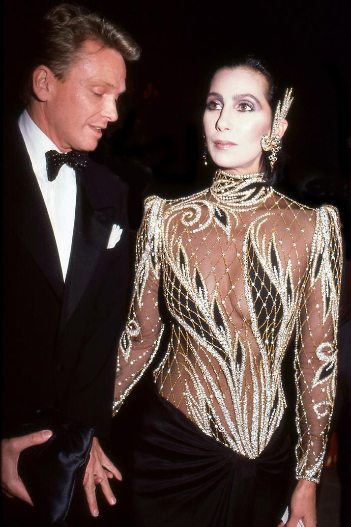 **1985: CHER in Bob Mackie**
<br><br>
Before the naked dress was a staple item of Beyoncé and Jennifer Lopez (and even Marc Jacobs), Cher pioneered the look in an era where showing your body was considered significantly more risqué. 
<br><br>
Her long-running collaboration with designer Bob Mackie produced a dizzying array of naked dresses that caused somewhat of a public meltdown—pictured here in a custom gown at the 1985 Met. Not all fashion heroes wear capes.
