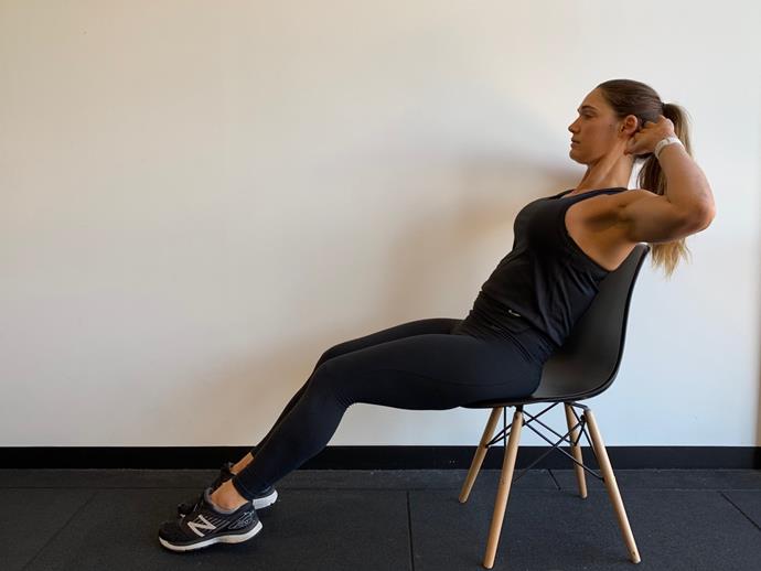 **Seated Crunch**<br><br>

Sit on the edge of chair and place your hands behind your head. Balance the toes lightly on the ground. Slowly lean your torso back towards the chair, and then crunch back up. Maintain a straight spine and brace through your lower core.<br><br>

*Complete 15 reps*