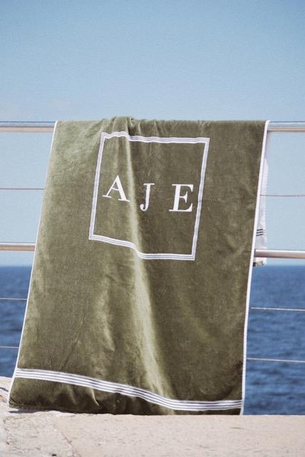 **Aje**
<br><br>
For oversized, tonal towels to complement your black Matteau bikini, look no further than Australian label Aje, whose neutral designs, emblazoned with their logo, are the perfect beach cover-up. With two designs on offer (between $114 and $145 in price), you can gift one and score another for yourself too. 
<br><br>
*Shop Aje towels [here](https://ajeworld.com.au/collections/towels|target="_blank"|rel="nofollow").*