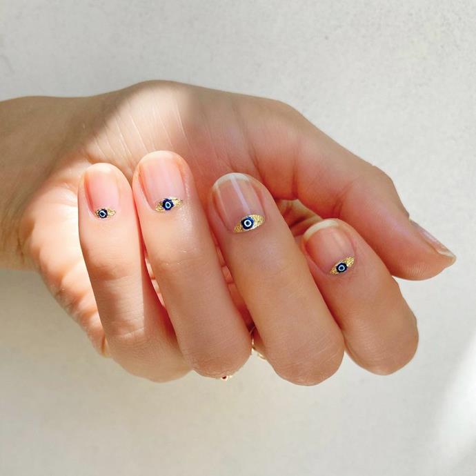 **The Evil Eye Manicure**
<br><br>
If you're looking to ward off some serious bad vibes, look no further than the [Evil Eye Manicure](https://www.elle.com.au/beauty/evil-eye-nail-art-23655|target="_blank"). Believed to be a form of protection, the talisman continues to make waves on social media. Forms of the popular symbol range from the traditional blue circle to the more eye-shaped iterations with gold leaf accents. Some of the simpler variations are easy enough to complete at home, but it's well worth a salon visit for the more intricate designs.
<br><br>
*Image via [@betina_goldstein](https://www.instagram.com/p/CJYnA1eswL7/|target="_blank"|rel="nofollow").*