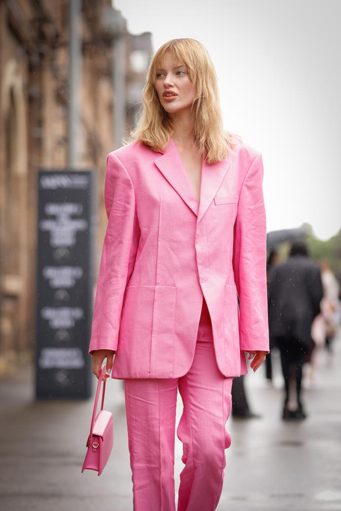 Elodie Russell wears a pink suit and Jacquemus pink leather clutch.
<br><br>
*Image credit: Getty Images.*