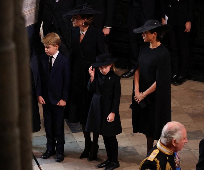 Prince George, Princess Kate, Princess Charlotte and Meghan, Duchess of Sussex wait to join the Royal procession Queen Elizabeth II's funeral.
