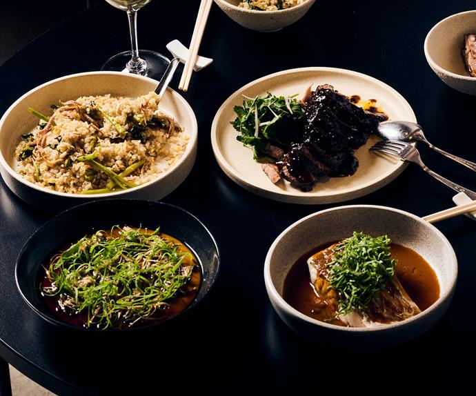 Four dishes on the table at Lagoon Dining in Carlton Melbourne: a rice dish, steamed fish with ginger.