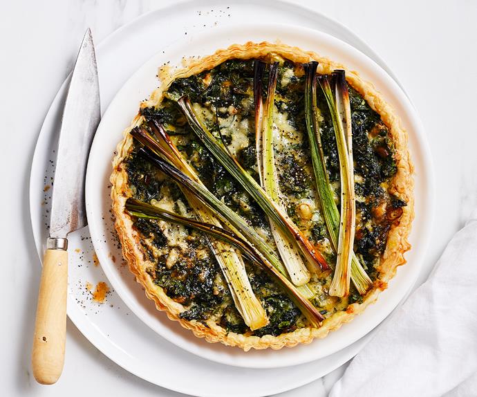 Aerial view of a circular tart topped with long slices of leeks.