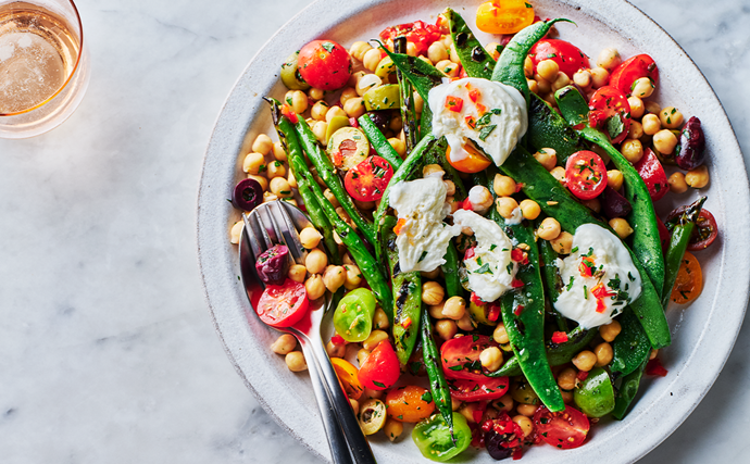 An aerial view of a warm mixed bean salad with chickpeas and topped with mozzarella.