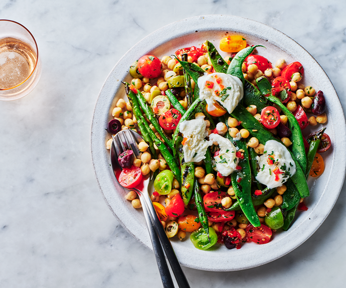 An aerial view of a warm mixed bean salad with chickpeas and topped with mozzarella.