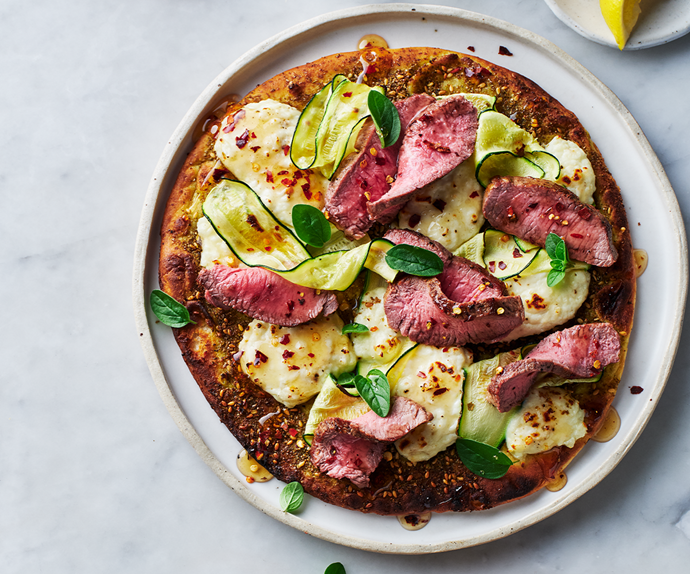 An aerial view of a lamb, zucchini and haloumi flatbreads with chilli honey