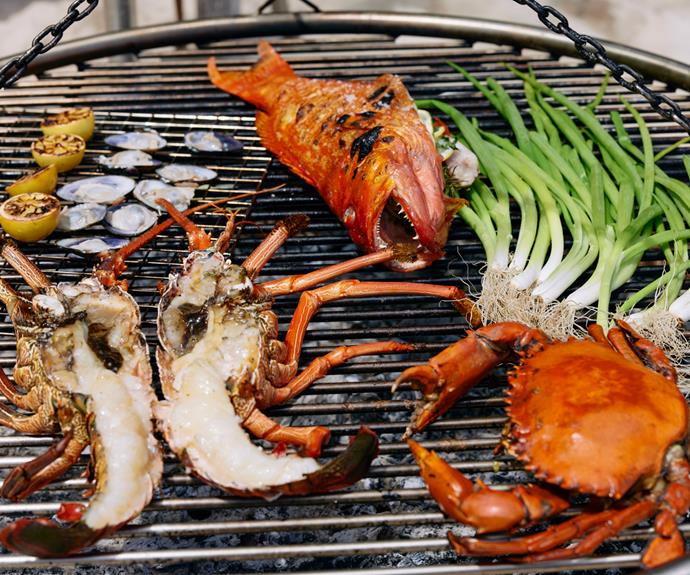 Freshly caught seafood cooking over coals