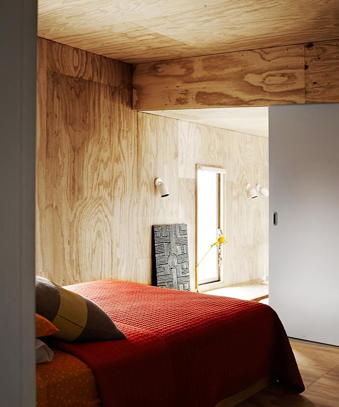 The bedroom is in a raised section of the extension, with sliding doors allowing for separation and privacy. The architect customised the clients' existing queen-size bed with a plywood base.