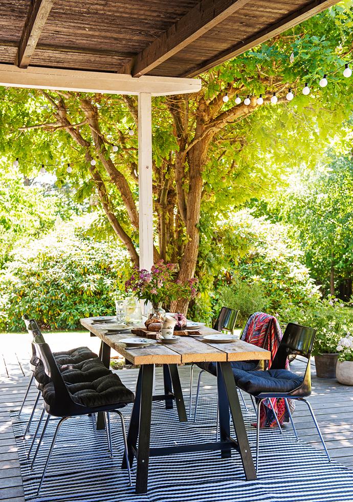 The semi-covered deck is the family's favourite dining spot during the warmer months. A plastic striped rug not only completes the look, but also protects the wooden flooring. The table is made from wooden boards on [Ikea](http://www.ikea.com.au/|target="_blank") trestle legs.