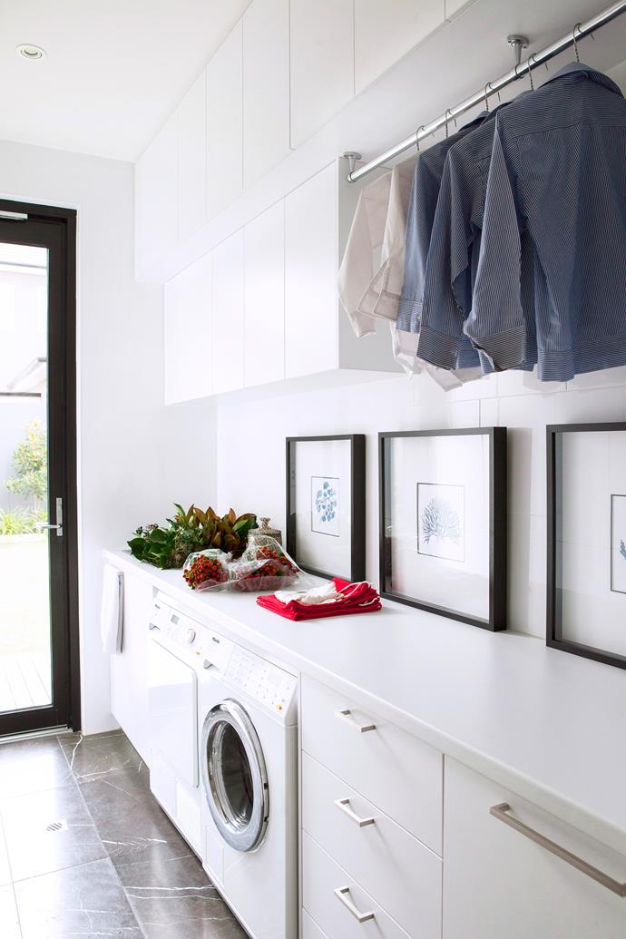 Located next to the kitchen, this Adelaide laundry, designed by [Max Pritchard Architect](http://www.maxpritchardarchitect.com.au/?utm_campaign=supplier/|target="_blank"), features Pietra Grey marble floor from [Affordable Tiles](https://affordabletiles.com.au/?utm_campaign=supplier/|target="_blank"), and plentiful bench space. "I included the Kerri Shipp prints because they add personality to the room," says the owner. "With a family of five I spend a lot of time folding clothes. I thought I might as well have some serene pictures to gaze at."