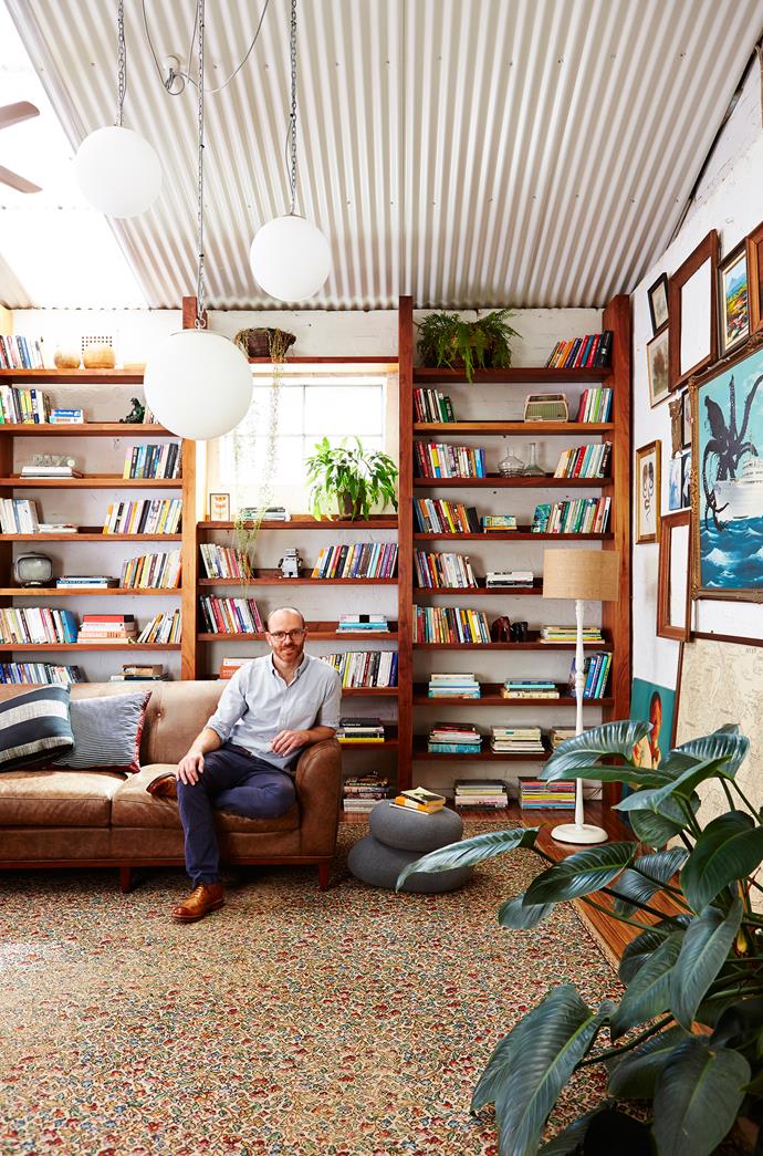 Interior architect and furniture designer [Andrew Waller](http://www.mrwaller.com/|target="_blank") perches in front of an impressive bookshelf. Photo: John Paul Urizar.