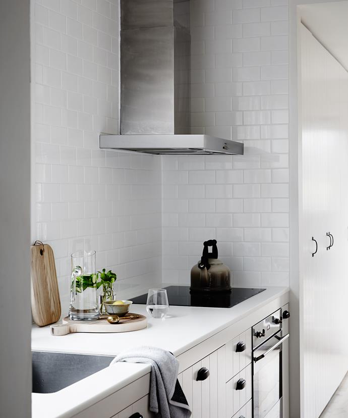 The small kitchen was gutted and redone with little decoration save for a select few pieces in natural materials, keeping it clean and simple – a typical Scandi-style modernist touch. White cabinetry and classic subway tiles are complemented with black handles.