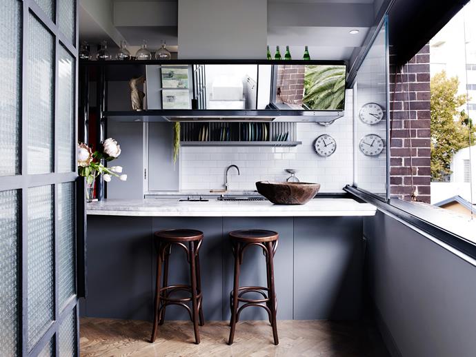 A collection of glossy black lacquerware from Burma sits above the dish-rack shelves in the kitchen.