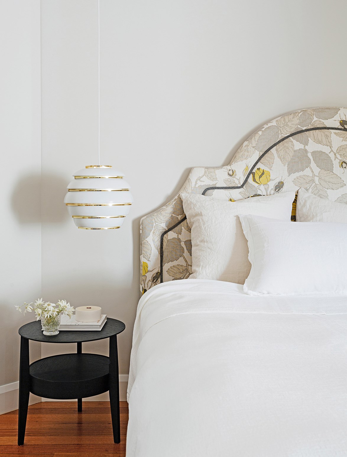 Crisp white sheets, fluffy pillows and a beautiful upholstered bedhead create a soft and dreamy place to rest in the bedroom of this [feminine Sydney home](https://www.homestolove.com.au/gallery-master-stroke-feminine-sydney-house-design-1-2021|target="_blank"). The brass pendant adds a welcomed touch of bling. Photo: Felix Forest / *real living*