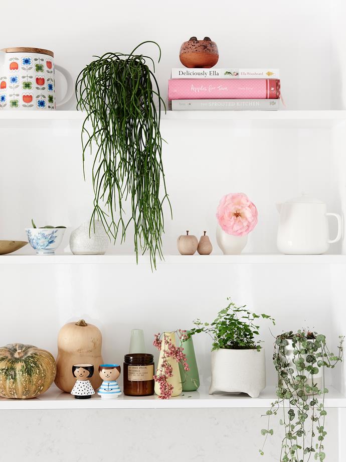 Knick-knacks and pops of pink and green enliven and personalise the otherwise minimalist kitchen.