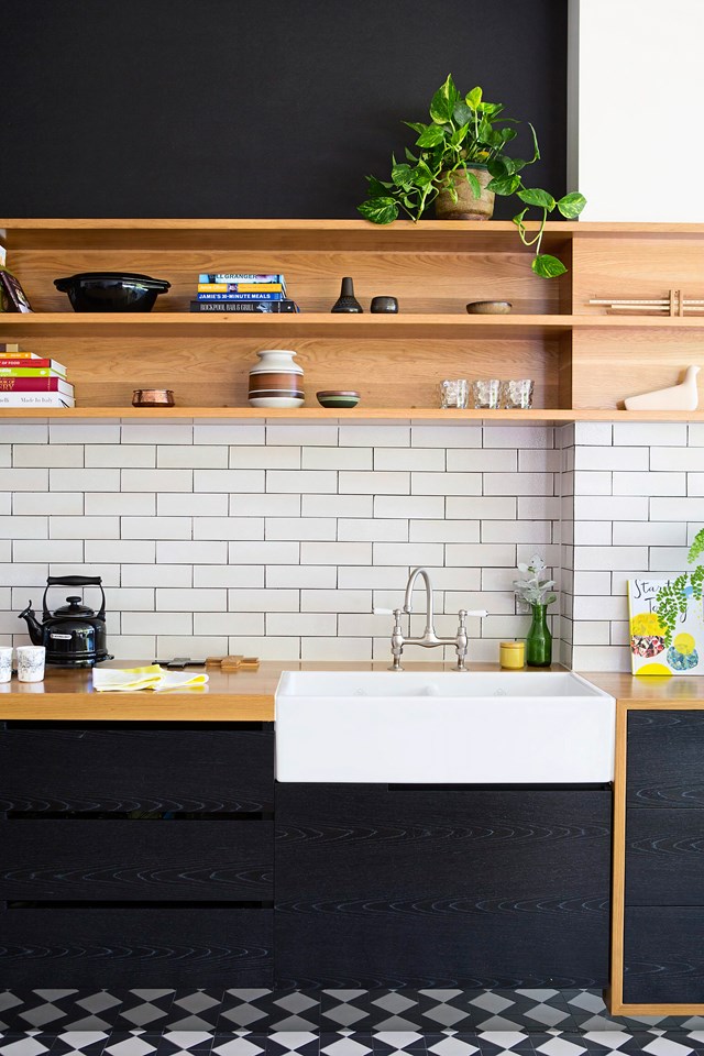 The owners of this [unique kitchen](http://www.homestolove.com.au/john-and-kylies-unique-kitchen-renovation-2344/|target="_blank") added warmth to the black veneer cabinets with the use of American oak insets and off-white subway tiles. The [patterned tile] floor also packs a punch!