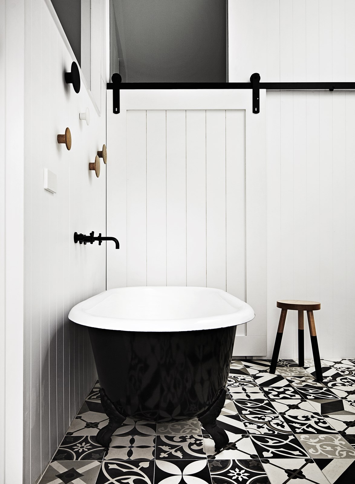 An unexpected hit of pattern is delivered in the monochromatic floor tiles from Bespoke Tile & Stone, in this classic monochrome bathroom.