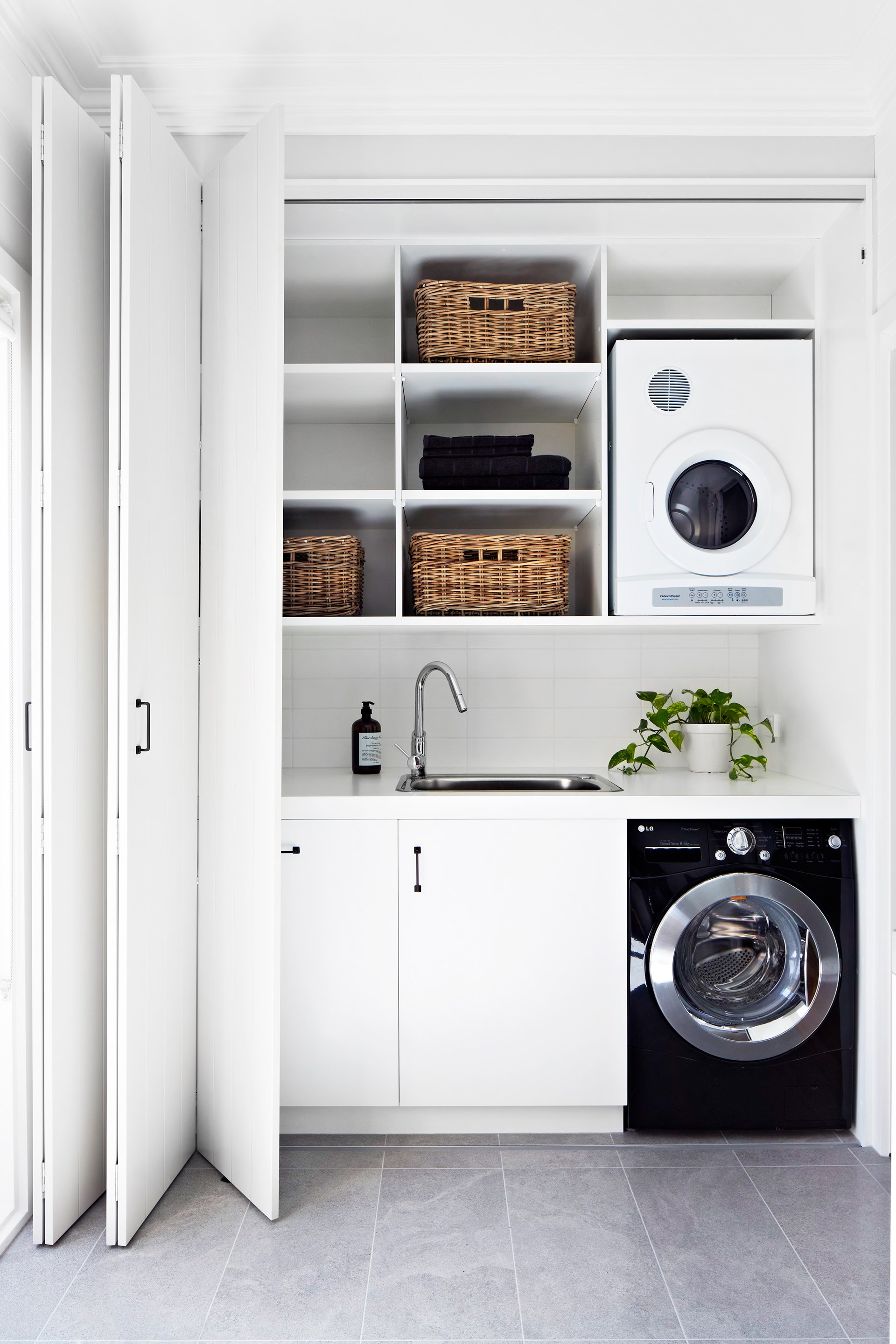 Keeping a [small laundry](https://www.homestolove.com.au/how-to-design-a-small-space-laundry-5269|target="_blank") like this is order means utilising any spare surface area for storage with built-in shelves, baskets and hooks. *Photo:* Armelle Habib / *Australian House & Garden*