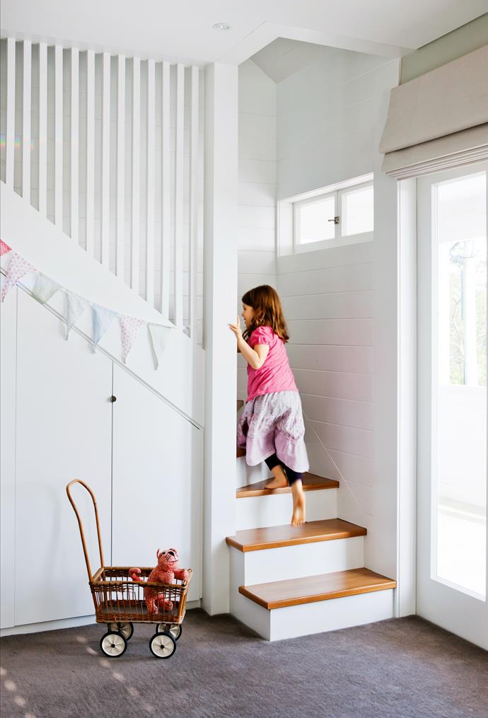 Jane’s youngest daughter climbs the stairs to the new playroom in the attic. The space under the stairs has been re-purposed as storage.