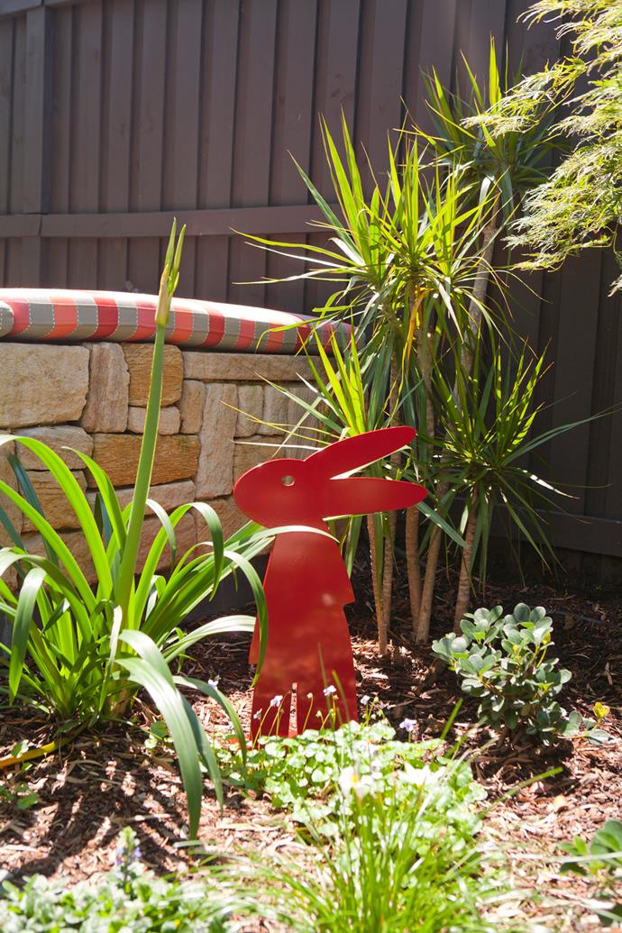 A cute bunny sculpture lives in the garden.