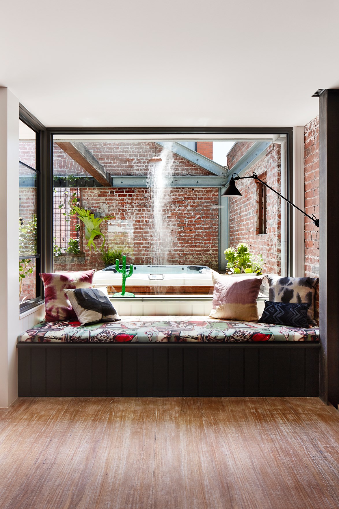 Positioned under a picture window, this built-in daybed overlooking the outdoor spa/shower area is a sought-after spot in this [lofty Melbourne warehouse](https://www.homestolove.com.au/cosying-up-a-melbourne-warehouse-conversion-3653|target="_blank"). *Photo:* Armelle Habib