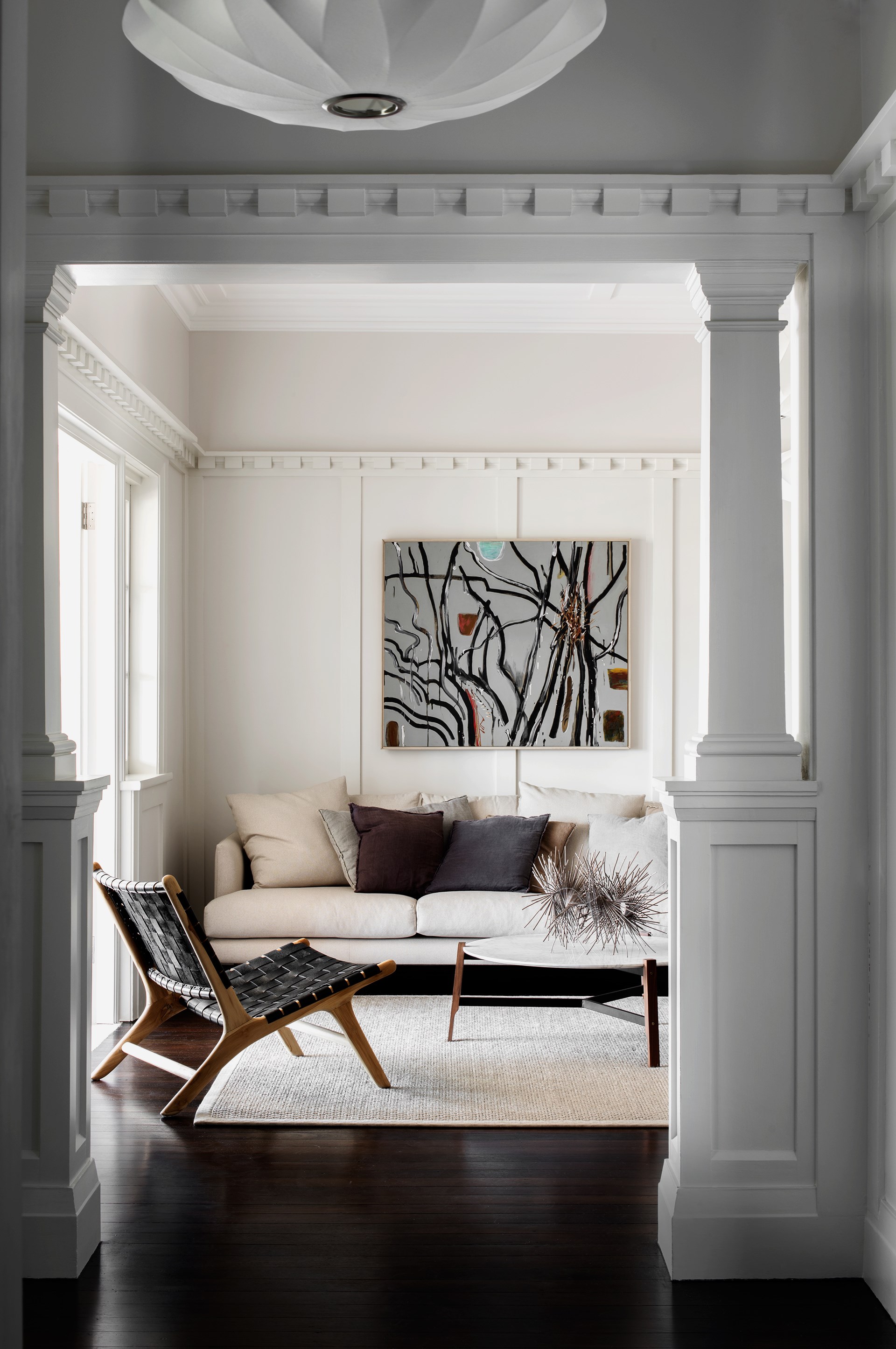 The interiors of [this restored bungalow](https://www.homestolove.com.au/sandstone-house-restored-to-former-glory-3731|target="_blank") in Palm Beach were painted white as not to compete with the heritage mouldings and exposed sandstone walls. An ornate picture rail draws the eye up to the original crown moulding that wraps the space. 