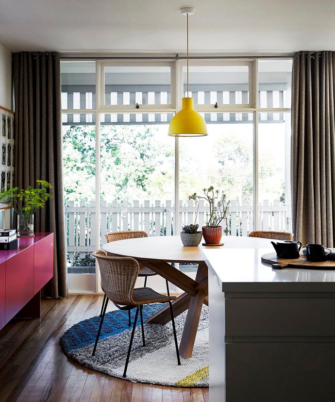 A round table works to maximise space in the dining zone and allows for easy passage without any sharp corners. More colour is injected via a stripy rug and custom-made fuchsia sideboard.