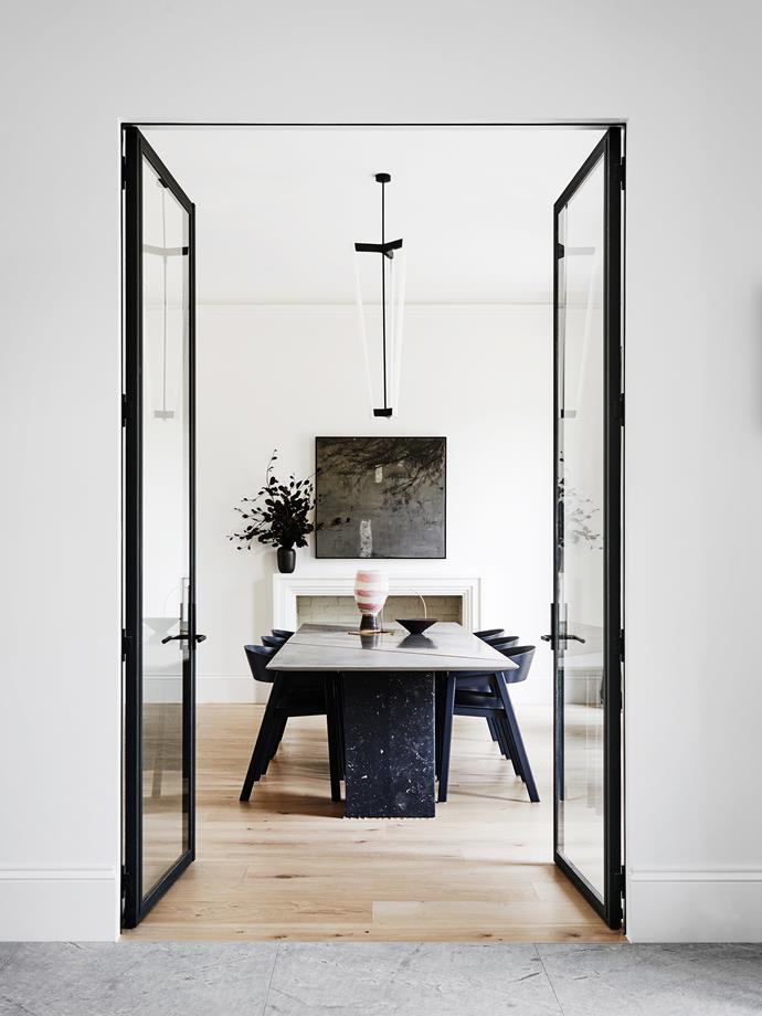 Dramatic glass doors lead the way to this chic dining room. Inside, a muted marble dining table sits in stark contrast to the white walls, making for simple yet sophisticated entertaining. Take a tour of the [modern monochrome home](http://www.homestolove.com.au/gaudy-80s-home-gets-modern-renovation-3877|target="_blank").