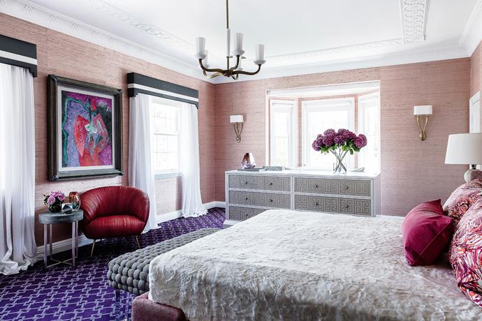 Brendan also exercised his licence for colour in the main bedroom, pairing textural pink grasscloth with a custom patterned purple carpet, bold timber grains and strong accent colours.